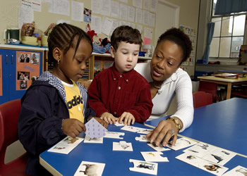 day care worker playing memory game with two kids
